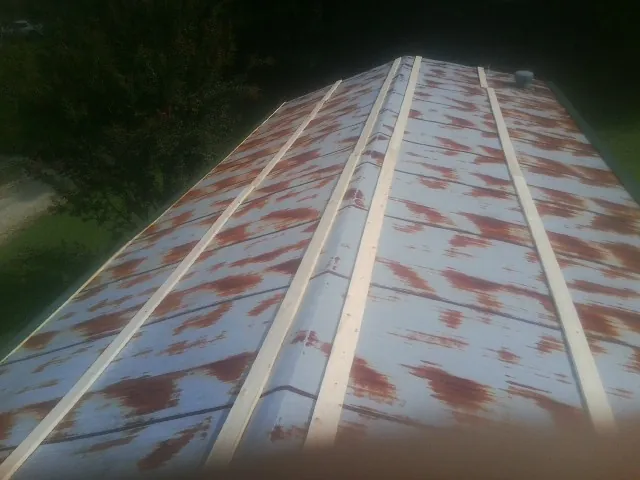 Rusted metal roof panels with new wood purlins before replacement — Storm Damage Roof Repair in Tuxedo Park by Roofing Brothers