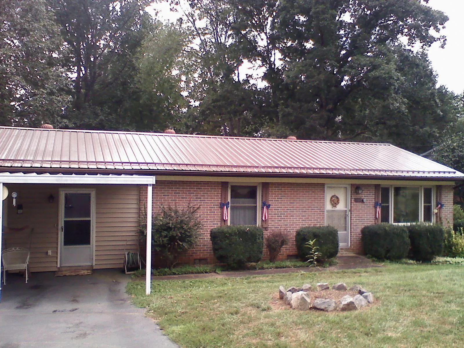 Bronze metal roof and carport on a brick ranch home — Roof Repair work by our crew in Tuxedo Park